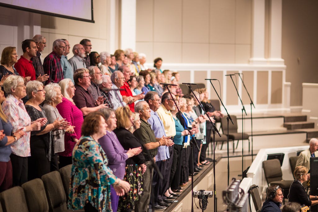Großer Chor mit Sängerinnen und Sängern unterschiedlichen Alters auf einer Bühne während einer Aufführung
