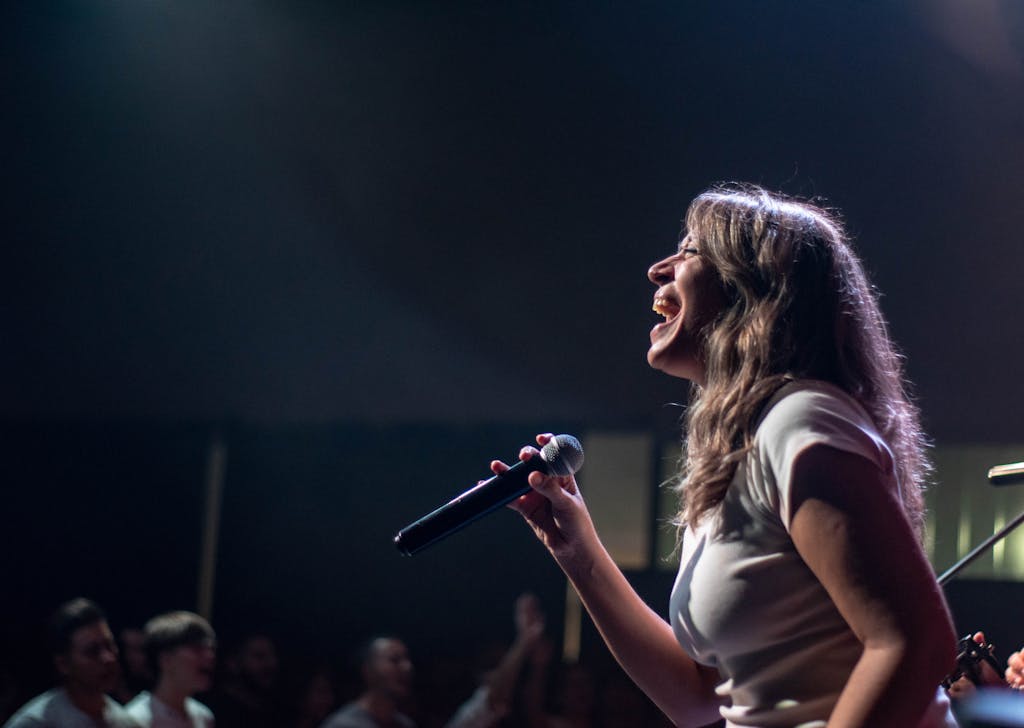 Charismatic female singer performing passionately on stage during a live concert.
